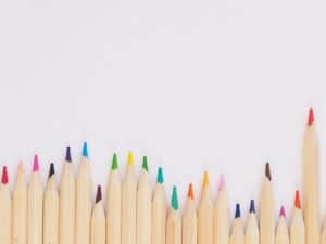 colored pencil lined up on top of white surface